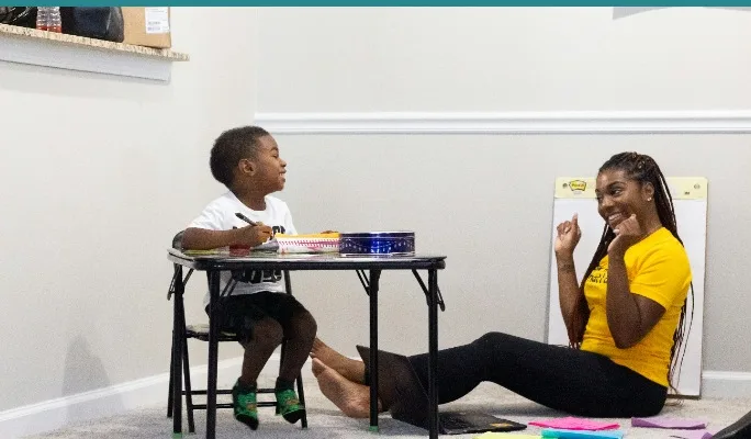 Child and behavioral health clinician working together at a desk at home