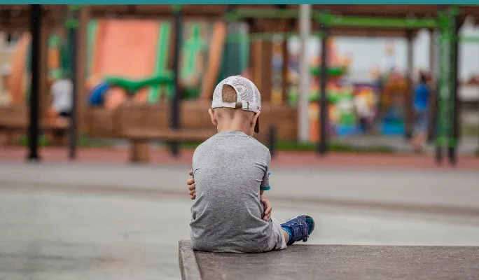 Child sitting alone at a playground