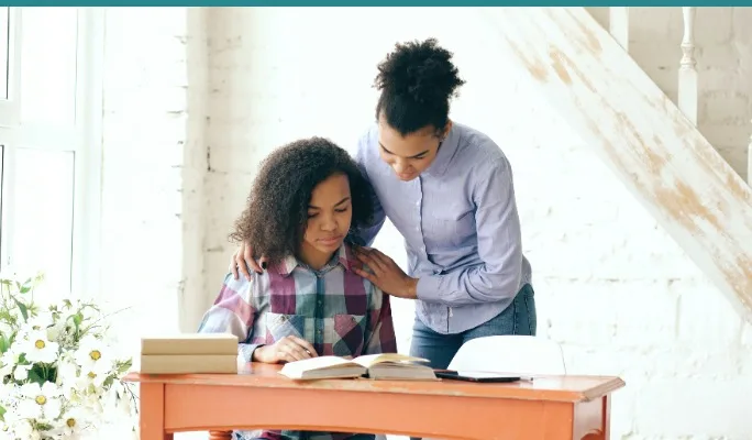 Mother supporting daughter with schoolwork at home